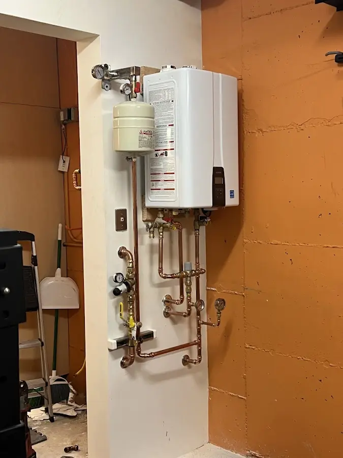Plumbing technician inspecting water heater connections in Carlinville